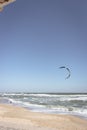 Kite surfing on the beach. Active lifestyle. Extreme sports concept. Man in wetsuit with kite board at seaside