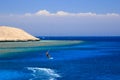 Kite surfing girl in swimsuit with kite in sky on board in blue sea riding waves with water splash. Recreational activity, Royalty Free Stock Photo