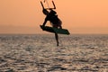 Kite surfing girl in swimsuit with kite in sky on board in sea jumping freestyle trick move. Recreational activity, water Royalty Free Stock Photo