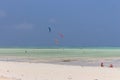 Kite surfing on tropical beach, low tide. Kite surfers on the sea. Scenic Indian Ocean with kite boards, Zanzibar, Paje beach.