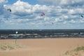 Kiters on the bay on a sunny windy day. People at the beach. Summer sport. Summer lifestyle.