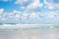 A lot of kiters and surfers in Tel Aviv under blue sky