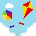 Kites fly in the clouds against the blue sky. Two realistic kites.