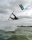 Kitesurfer doing an unhooked trick with the kite in the frame on an overcast day at the baltic sea