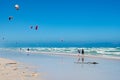 Couple looking from beach to kitesurfer. Kiteboarder in high waves on the sea in Kalk Bay, South Africa. Royalty Free Stock Photo