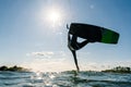 Kitesurfer jumping and doing a trick with beautiful sun star behind