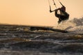 Kitesurfer riding in beautiful yellow sunset conditions Royalty Free Stock Photo