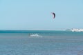 Kitesurfer riding ocean waves on a bright sunny day