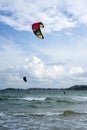 Kitesurfers ride kites on Black Sea at sandy Beach In Bulgaria, Sozopol on sunny day at sunset on blue sky and clouds background. Royalty Free Stock Photo