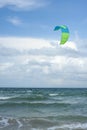 Kitesurfers ride kites on Black Sea at sandy Beach In Bulgaria, Sozopol on sunny day at sunset on blue sky and clouds background. Royalty Free Stock Photo