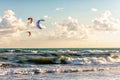 Kitesurfers ride kites through surfing waves of stormy Black Sea at sandy beach by Anapa Royalty Free Stock Photo