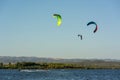Kitesurfers riding near Punta Trettu, near Cagliari, in Sardinia, Italy, at Golden hour on Blurred Coastline background