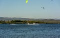 Kitesurfers riding near Punta Trettu, near Cagliari, in Sardinia, Italy, at Golden hour on Blurred Coastline background