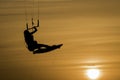 Kitesurfing girl silhouette jumping at golden hour sunset woman kiteboarding jump Royalty Free Stock Photo