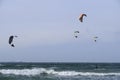 Kitesurfing, riding board waves during storm holding to flying kite. Royalty Free Stock Photo