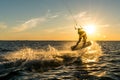 Silhouette of kitesurfer doing unhooked jump in sunset with sun star Royalty Free Stock Photo