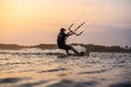 kitesurfing. A surfer rides on a beautiful backdrop of bridges and coastline at sunset and performs all kinds of stunts