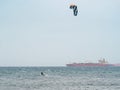 Kitesurfing During a Windy Day with a Very Rough Sea and Industrial Boat in the background Royalty Free Stock Photo