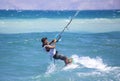 Kitesurfing. The young man is flying on the sea wave on the Board.