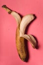 Kitsch styling banana peeled on a pink background