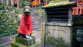Kitsune japanese fox statue with red apron at famous Fushimi Inari Taisha shrine Royalty Free Stock Photo