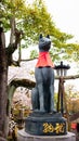 Kitsune japanese fox statue with red apron at famous Fushimi Inari Taisha shrine Royalty Free Stock Photo