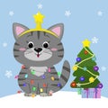 The kitten sits gray. He wears a garland with a tree and a star on his head, with a gift and a Christmas tree on the background of
