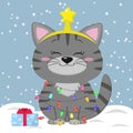 Kitten is sitting gray. He wears a garland with a Christmas tree and a star on his head, with a gift on the background of snow.