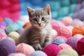 Kitten among yarn balls, cute, colorful background. Royalty Free Stock Photo