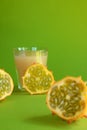 Kiwano slice, exotic vegetable cucumis metuliferus and a glass of fruit juice on a green background. Soft focus. Vegetarian food