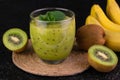 Kiwi banana smoothie in a glass on a black background.Close-up. Royalty Free Stock Photo