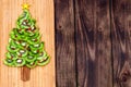 Kiwi Christmas tree - fun food idea for kids party or breakfast, New Year food on wooden background. Christmas tree food concept. Royalty Free Stock Photo