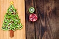 Kiwi Christmas tree - fun food idea for kids party or breakfast, New Year food on wooden background. Christmas tree food concept. Royalty Free Stock Photo