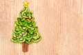 Kiwi Christmas tree - fun food idea for kids party or breakfast, New Year food on wooden background. Christmas tree food concept. Royalty Free Stock Photo