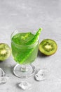 Kiwi cold refreshing drink in a glass with a straw and mint on a gray concrete background. Selective focus Royalty Free Stock Photo