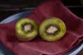 Kiwi cut in two halfs in a wooden table