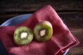 Kiwi cut in two halfs in a wooden table