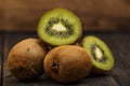 Kiwi fresh whole and halves on a black wooden table. Kiwi fruit is useful. Royalty Free Stock Photo