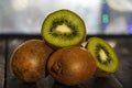 Kiwi fresh whole and halves on a black wooden table. Kiwi fruit is useful. Royalty Free Stock Photo