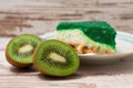 Kiwi fruit cut in half on white board in front of green cake Royalty Free Stock Photo