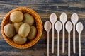 Kiwi fruits with spoons in a wicker basket on wooden background, flat lay Royalty Free Stock Photo