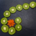 Kiwi fruits were cut into circles and laid out on a black stone tile