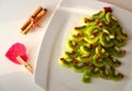 Kiwi and pomegranate Christmas tree New Year background. Healthy dessert idea for kids party