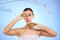 Kiwi, portrait and water splash of woman, beauty and wellness on studio blue background. Female model, shower and Royalty Free Stock Photo