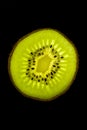 Kiwi slice backlited in a black background