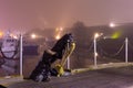 Klaipeda, Lithuania - 01 01 2021: Foggy New Year night in the city. Black Ghost monument next to Old Mill Hotel holding a lantern Royalty Free Stock Photo