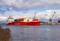 Klaipeda, Lithuania - 02 06 21: huge red cargo container ship on winter Curonian lagoon in front of terminal industrial Royalty Free Stock Photo