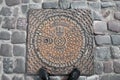 KLAIPEDA, LITHUANIA - JUNE 22, 2013: Sewer metal round hatch on pavement stone surface