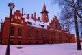 Klaipeda, Lithuania - 01 15 21: Old historical Neo-Gothic University building campus in winter snow, pink sunset colors