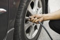 Man driver hand inflating tires of vehicle, removing tire valve nitrogen cap for checking air.